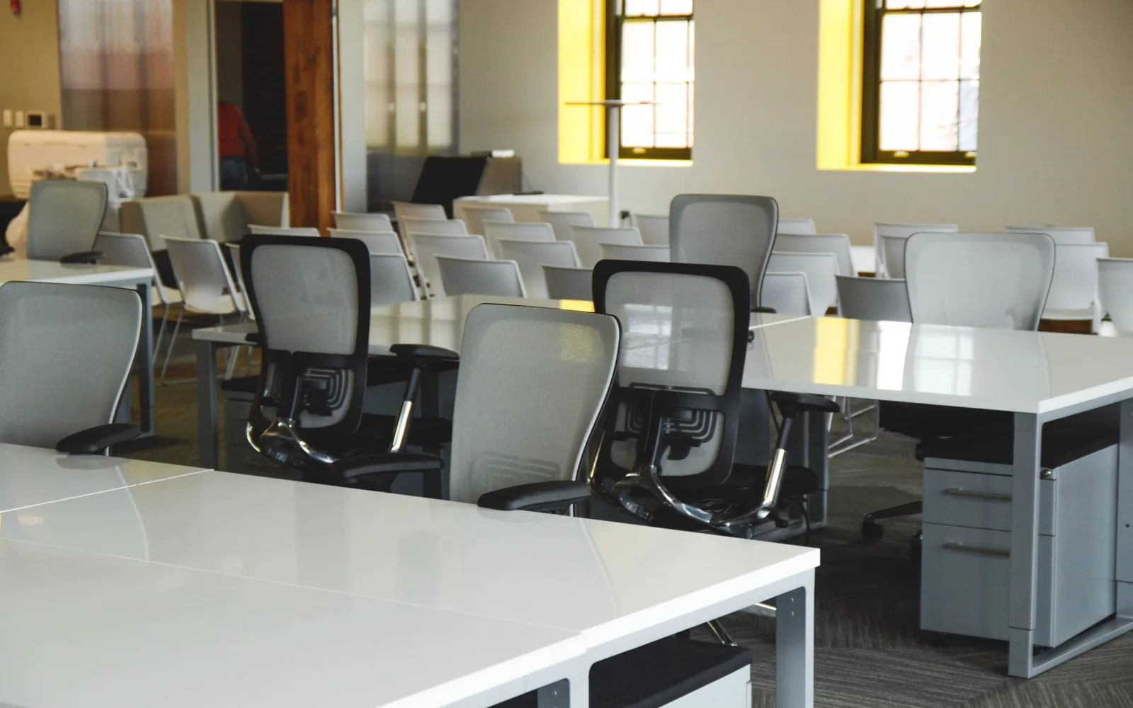 Bureau ouvert avec plusieurs postes de travail, vu depuis l’entrée.