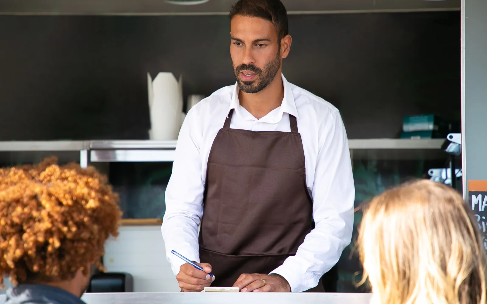 Devis manuscrit et stylo posés sur le comptoir d’un commerce.