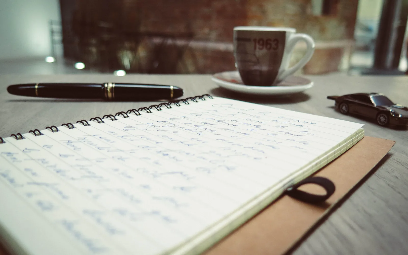 Carnet de notes ouvert et stylo sur un bureau, avec des notes de travail.